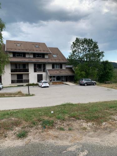 ein Gebäude mit zwei Autos auf einem Parkplatz in der Unterkunft Motel - Location studio 2 personnes in Morbier