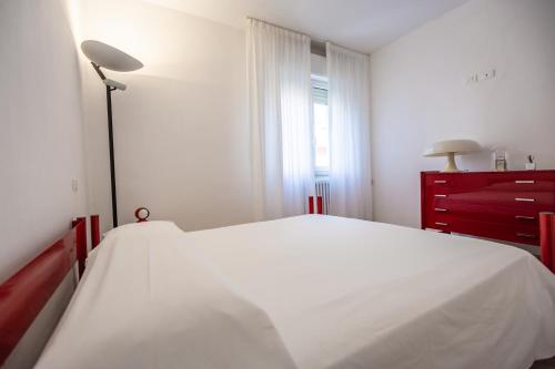 a bedroom with a white bed and a red dresser at Casa Summer in Cecina