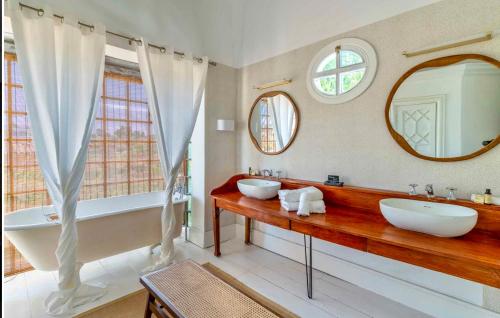 ein Badezimmer mit zwei Waschbecken, einer Badewanne und einem Spiegel in der Unterkunft The Pearl - Marbella in Marbella