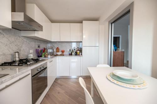 a kitchen with white cabinets and a white counter top at Casa Summer in Cecina