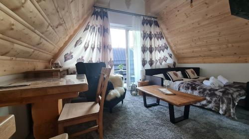 a bedroom with a bed and a desk in a room at Pokoje Kubikowe in Ząb