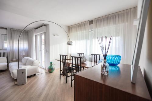 a living room with a kitchen and a living room with a table at Casa Summer in Cecina