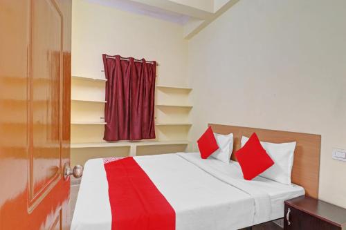 1 dormitorio con 1 cama con almohadas rojas y puerta en 80983G RBS Square Langer Houz en Haidar Sāhibgūda
