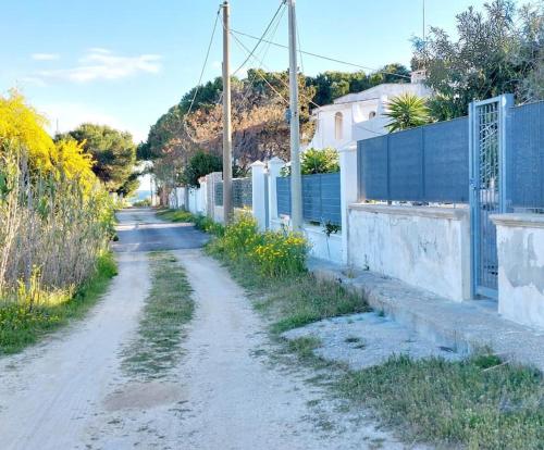 un camino de tierra con una valla azul a un lado en apartment Grace, just 200 meter from beach, Campomarino Madonnina, en Torre Ovo