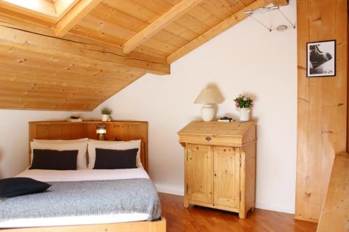 Serenity Escapes - Caldonazzo Lake في تينّا: غرفة نوم بسرير وسقف خشبي
