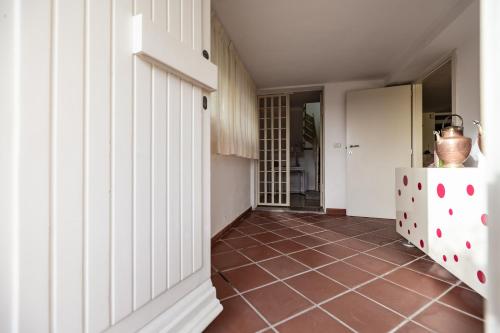 a hallway with white walls and a tiled floor at Casa Summer in Cecina