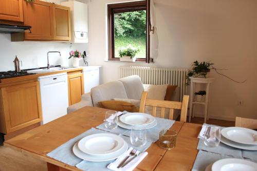 a kitchen and dining room with a table with plates on it at Serenity Escapes - Caldonazzo Lake in Tenna 