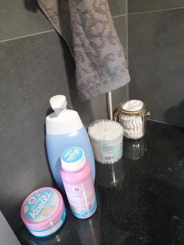 a bathroom counter with a bottle of lotion and other items at Vrnjačka Promenada - Pešačka zona - Baby friendly in Vrnjačka Banja