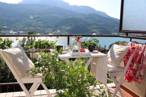 a table and chairs on a balcony with a view at Serenity Escapes - Caldonazzo Lake in Tenna 