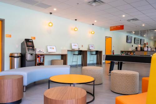 a room with tables and chairs and a counter at SPOT X Hotel Orlando Intl Dr by The Red Collection in Orlando