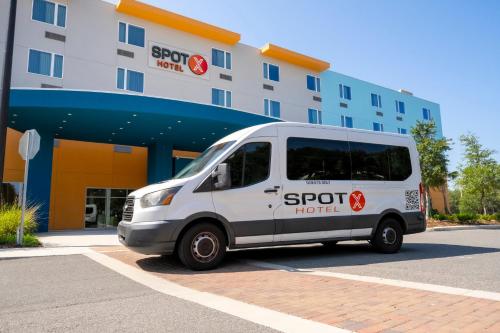 a white van parked in front of a hotel at SPOT X Hotel Orlando Intl Dr by The Red Collection in Orlando