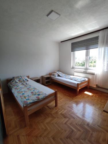 a room with two beds and a window at Villa Hana in Doglodi