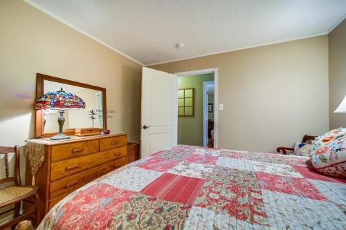 a bedroom with a bed and a dresser and a mirror at Fire Pit and Mtn Views North Carolina Abode! in Sylva