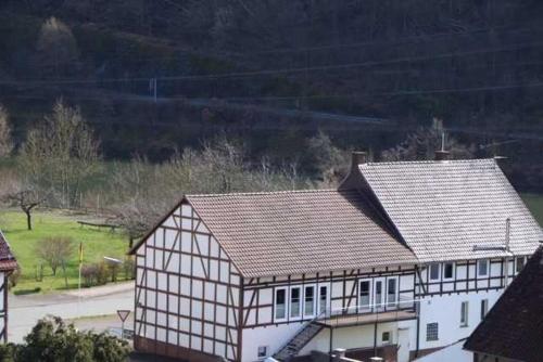 a large white house with a gray roof at Ferienwohnungen Eder_Ufer in Hemfurth-Edersee