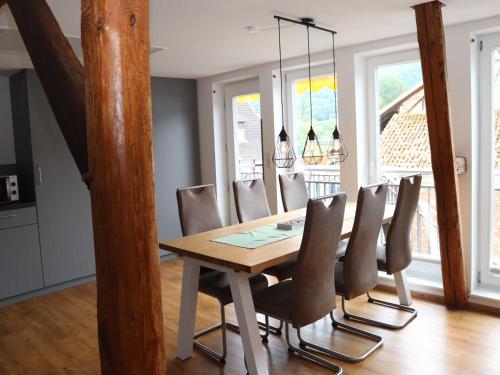 a dining room with a wooden table and chairs at Ferienwohnungen Eder_Ufer in Hemfurth-Edersee