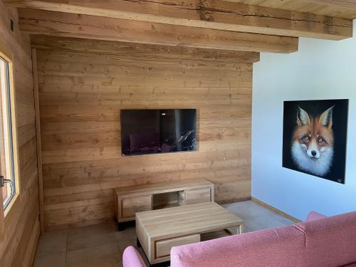 a living room with a fox painting on the wall at Chalets Coeur du Lac in Malbuisson