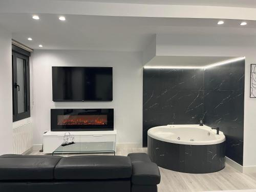 a living room with a tub and a fireplace at Black and White Suite Castro Urdiales in Castro-Urdiales