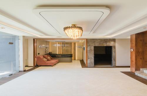 a living room with a couch and a chandelier at Krishna Residency - A Boutique Hotel in Bareilly