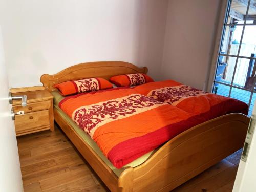 a bedroom with a wooden bed with an orange blanket at Jakobstränke 