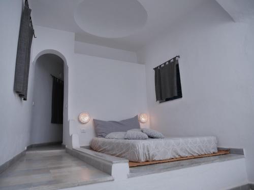 a bedroom with a bed in a white wall at Dar Ennour Djerbahood Erriadh in Houmt Souk
