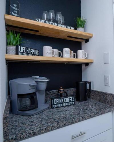 a kitchen counter with a coffee maker and coffee cups at Modern Oasis! 3BR Townhouse in a Lagoon Community in Wesley Chapel