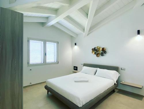 a bedroom with a white bed and a window at Villa Lorisa in Tanaunella