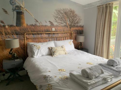 een slaapkamer met een bed met handdoeken erop bij Peaceful Norfolk Broads 1 Bedroom 2 bath annexe in Halvergate