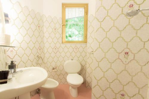 La salle de bains est pourvue de toilettes et d'un lavabo. dans l'établissement Casa Vinicia, à Equi Terme
