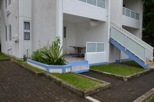 a building with a blue staircase in front of it at Les Gentilhommieres Guest House in Trou aux Biches