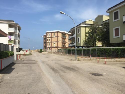 una calle vacía con edificios y un semáforo en GARDENIA, en Campomarino