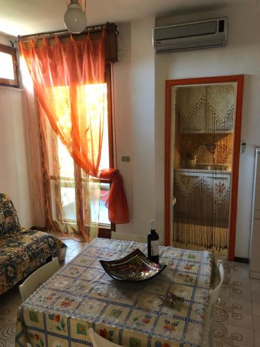 Zimmer mit einem Tisch, einem Sofa und einem Fenster in der Unterkunft GARDENIA in Campomarino