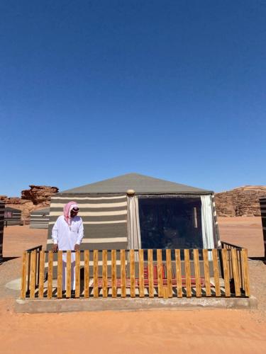 une personne assise sur un banc dans le désert dans l'établissement Desert's Soul Wadi Rum, à Disah