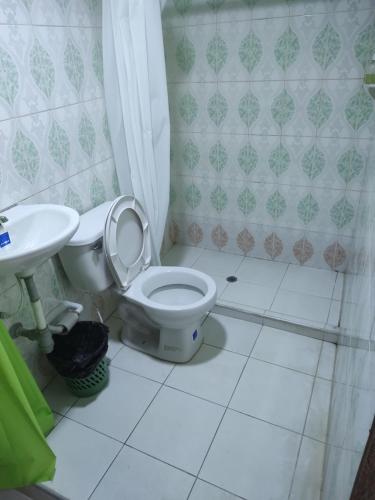 y baño con aseo y lavamanos. en Casa hospedaje mayesty, en San Cipriano