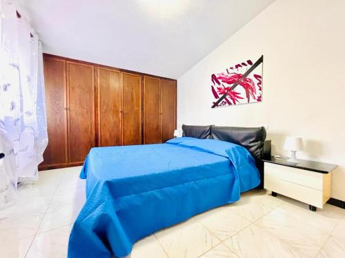 una camera con letto blu e armadi in legno di Daruma Apartment a Siniscola