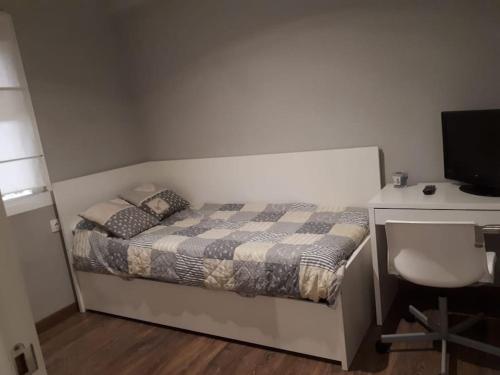 Schlafzimmer mit einem Bett und einem Schreibtisch mit einem Computer in der Unterkunft Apartamento en Cádiz playa Victoria in Cádiz
