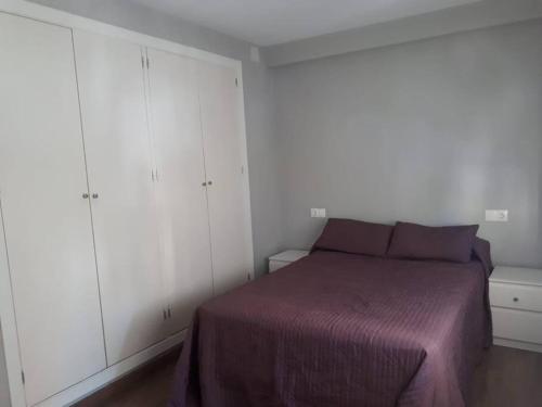 Schlafzimmer mit einem Bett und weißen Schränken in der Unterkunft Apartamento en Cádiz playa Victoria in Cádiz
