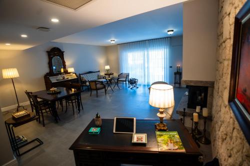 a living room with a desk and a living room with a table at Zena Hotel Alaçatı Adults Only in Alacati