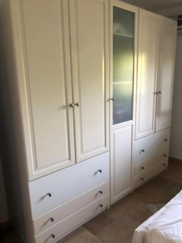 einen weißen Schrank mit weißen Schränken im Schlafzimmer in der Unterkunft VILLA MARILENA in Andriace