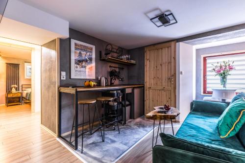 a living room with a green couch and a bar at Apartament Żubry z Sauna in Zakopane