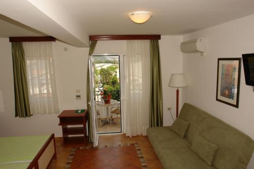 ein Wohnzimmer mit einem Sofa und einem Tisch in der Unterkunft Apartments Ivona in Budva