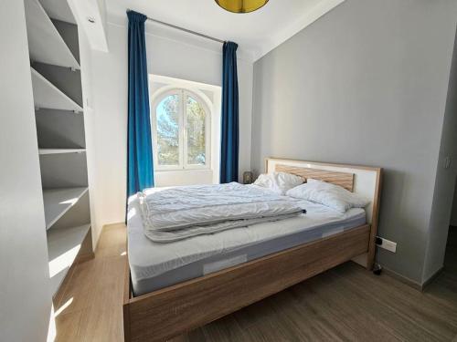 - une chambre avec un lit doté de rideaux bleus et d'une fenêtre dans l'établissement 3 pièces vue mer sur le Cap Martin, à Roquebrune-Cap-Martin