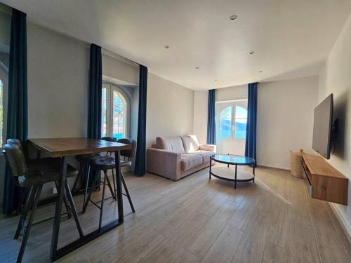 un salon avec une table et un canapé dans l'établissement 3 pièces vue mer sur le Cap Martin, à Roquebrune-Cap-Martin