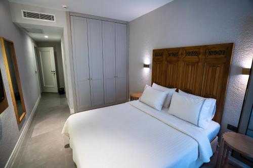 a bedroom with a large bed with white sheets and pillows at Zena Hotel Alaçatı Adults Only in Alacati