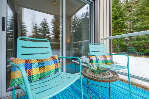 two blue rocking chairs sitting on a screened porch at Wildwood Lodge by Outpost Whistler in Whistler