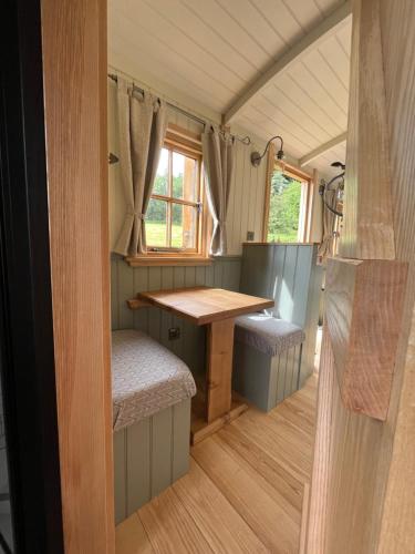 einen Essbereich in einem winzigen Haus mit einem Tisch und Stühlen in der Unterkunft Troytown Farm Shepherds hut in Puddletown