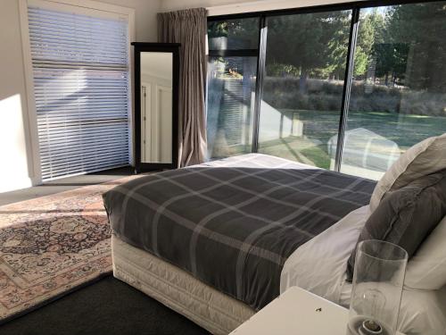 a bedroom with a bed and a large window at 4 Bedroom on North West Arch - Free Wifi in Twizel