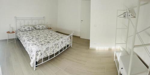 ein weißes Schlafzimmer mit einem Bett und Holzboden in der Unterkunft aria di mare levante in Torino di Sangro
