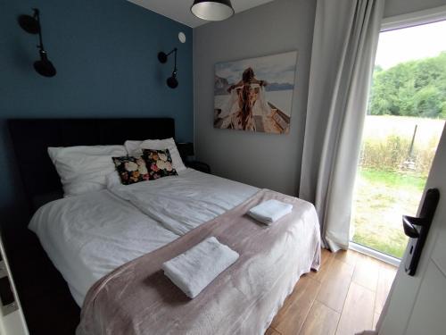 una camera da letto con un letto con due asciugamani sopra di Domki La Bella 1 a Aleksandria