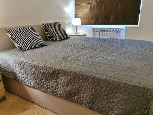 a bed with two pillows on it in a bedroom at Horizon Lu Apartment by the Sea in Sopot