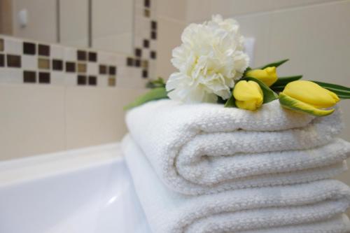 a stack of towels with yellow and white flowers on them at Horizon Lu Apartment by the Sea in Sopot